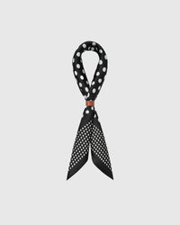 STICKYZOO midnight dot silk scarf draped in a ribbon fold with a leather slide showing the polka print