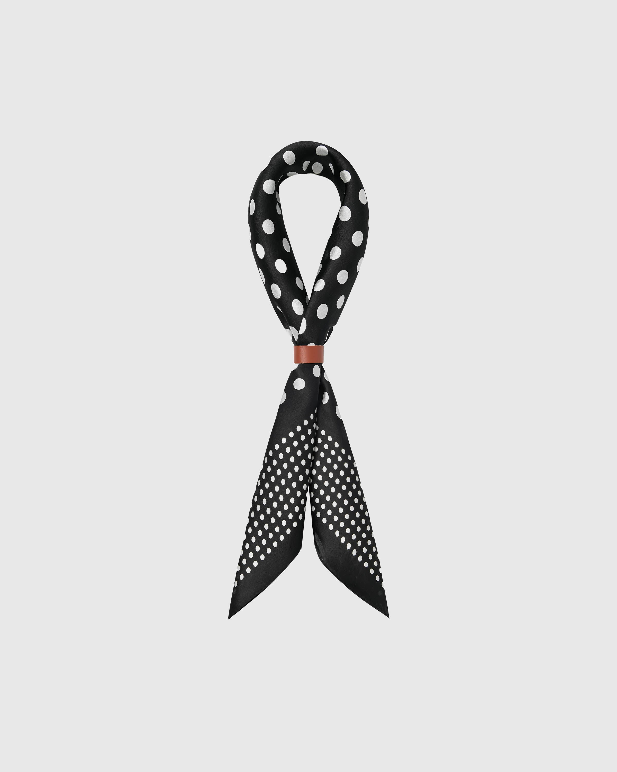 STICKYZOO midnight dot silk scarf draped in a ribbon fold with a leather slide showing the polka print