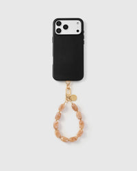Full phone with blush marble strap attached on light grey background