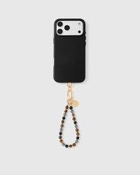 Multi-stone phone strap hanging from black phone case showing wrist carry functionality