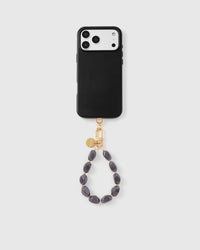 Full phone with storm agate strap attached on light background