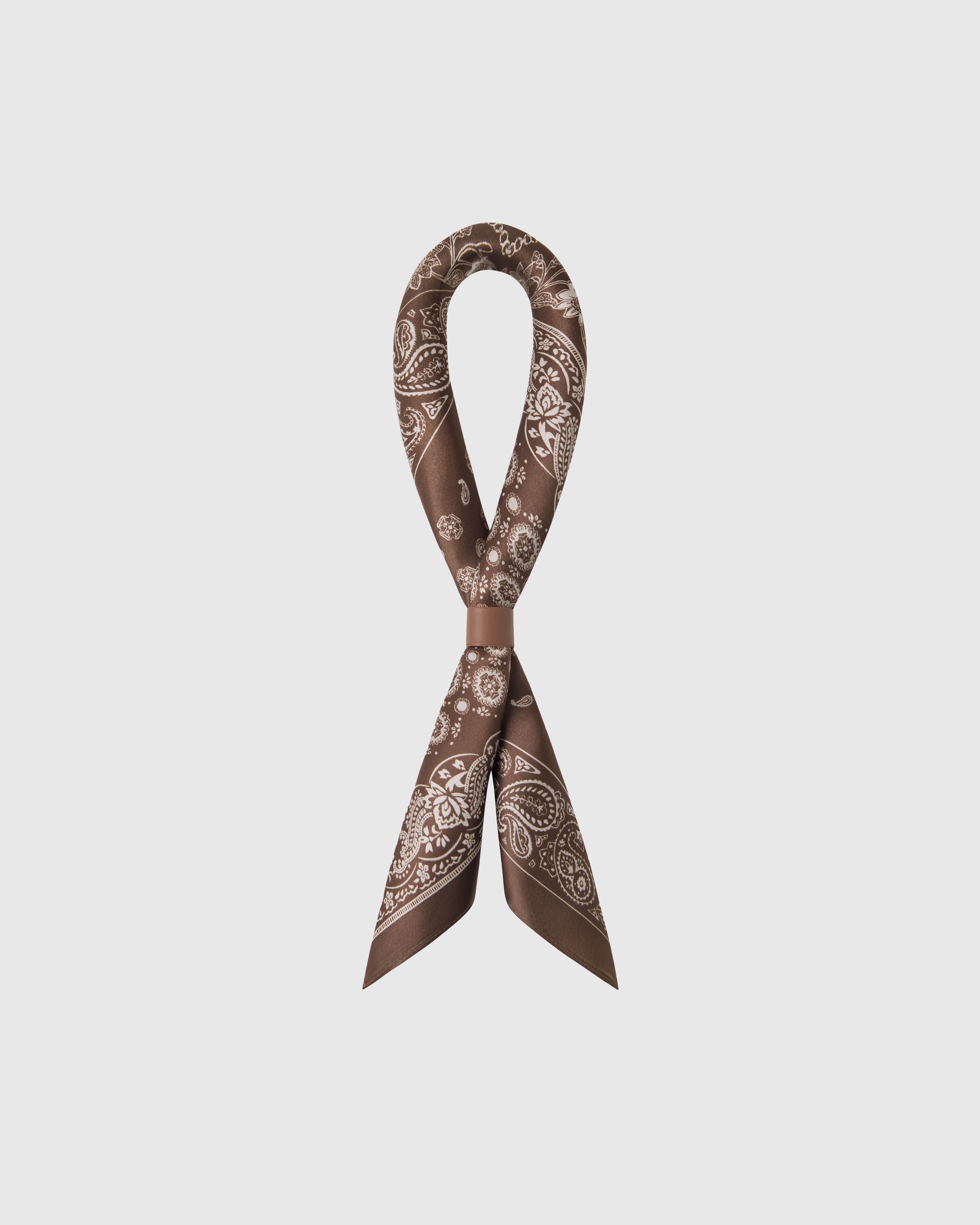 STICKYZOO cocoa patchwork silk scarf looped through a leather ring showing how the paisley panels fall