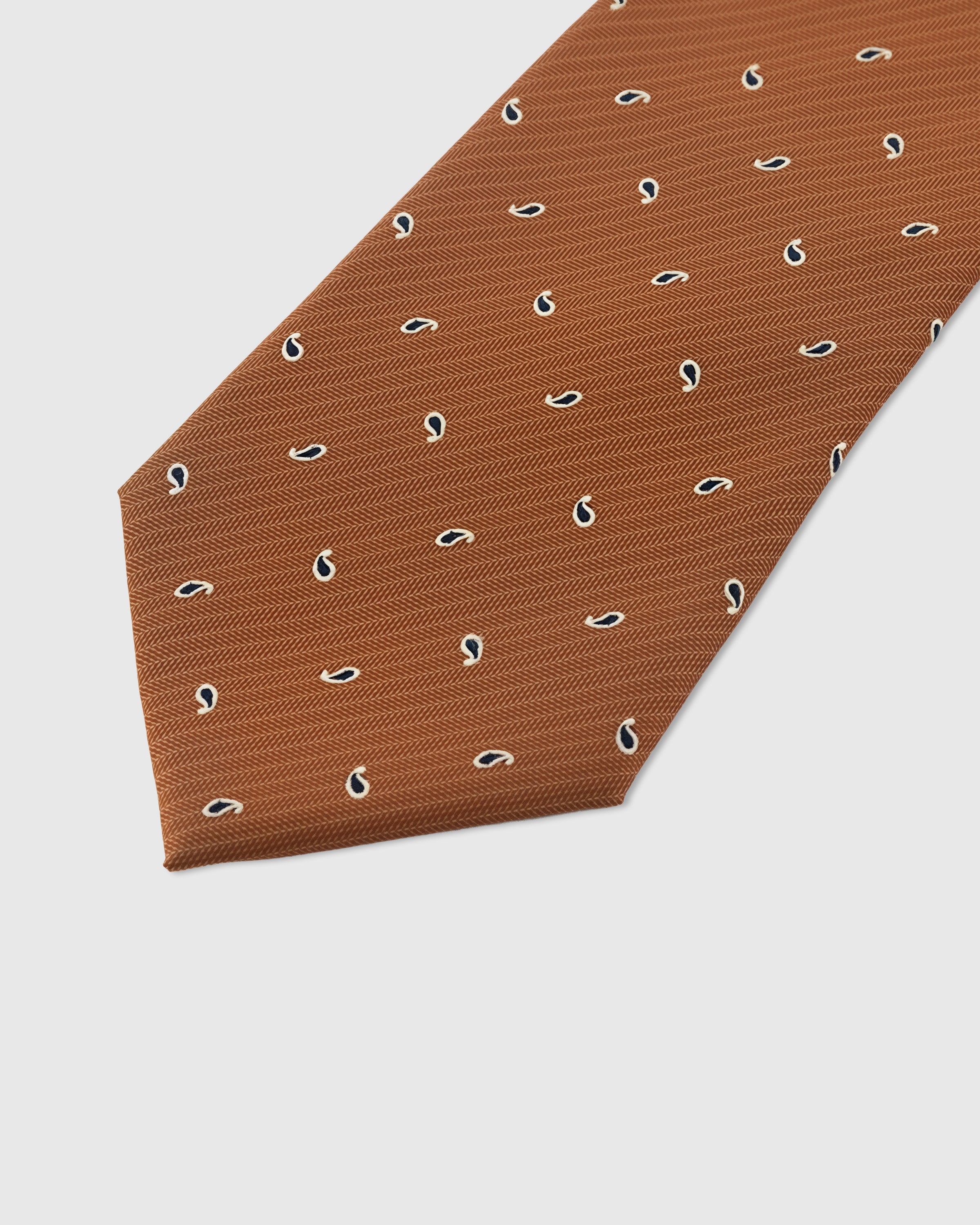 Paisley drop detail on terracotta mulberry silk tie showing hand-embroidered navy motifs by STICKYZOO