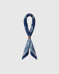 STICKYZOO indigo bandana silk scarf looped through a leather ring showing the paisley print drape