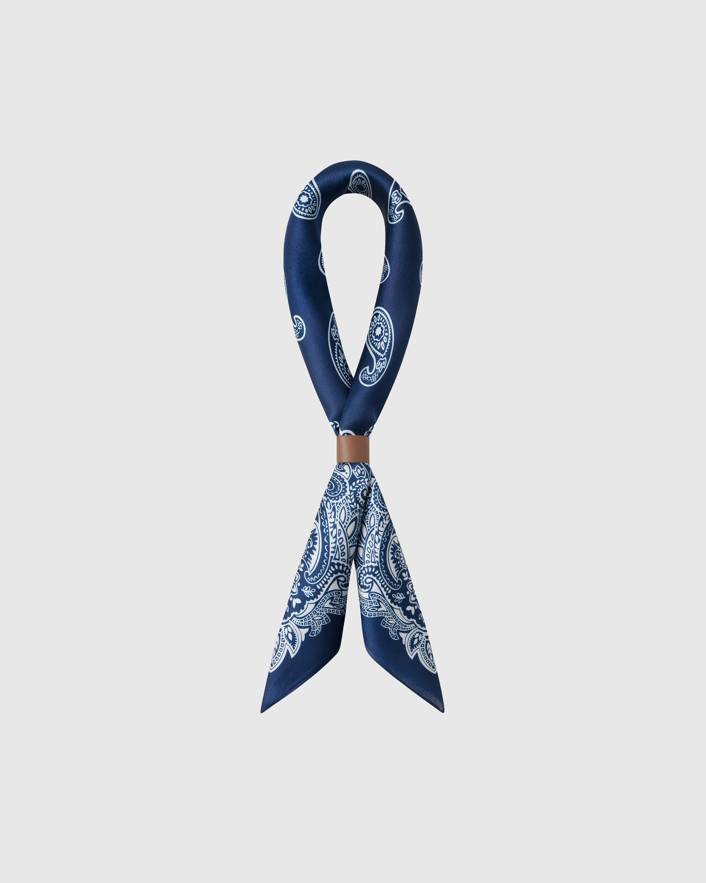 STICKYZOO indigo bandana silk scarf looped through a leather ring showing the paisley print drape