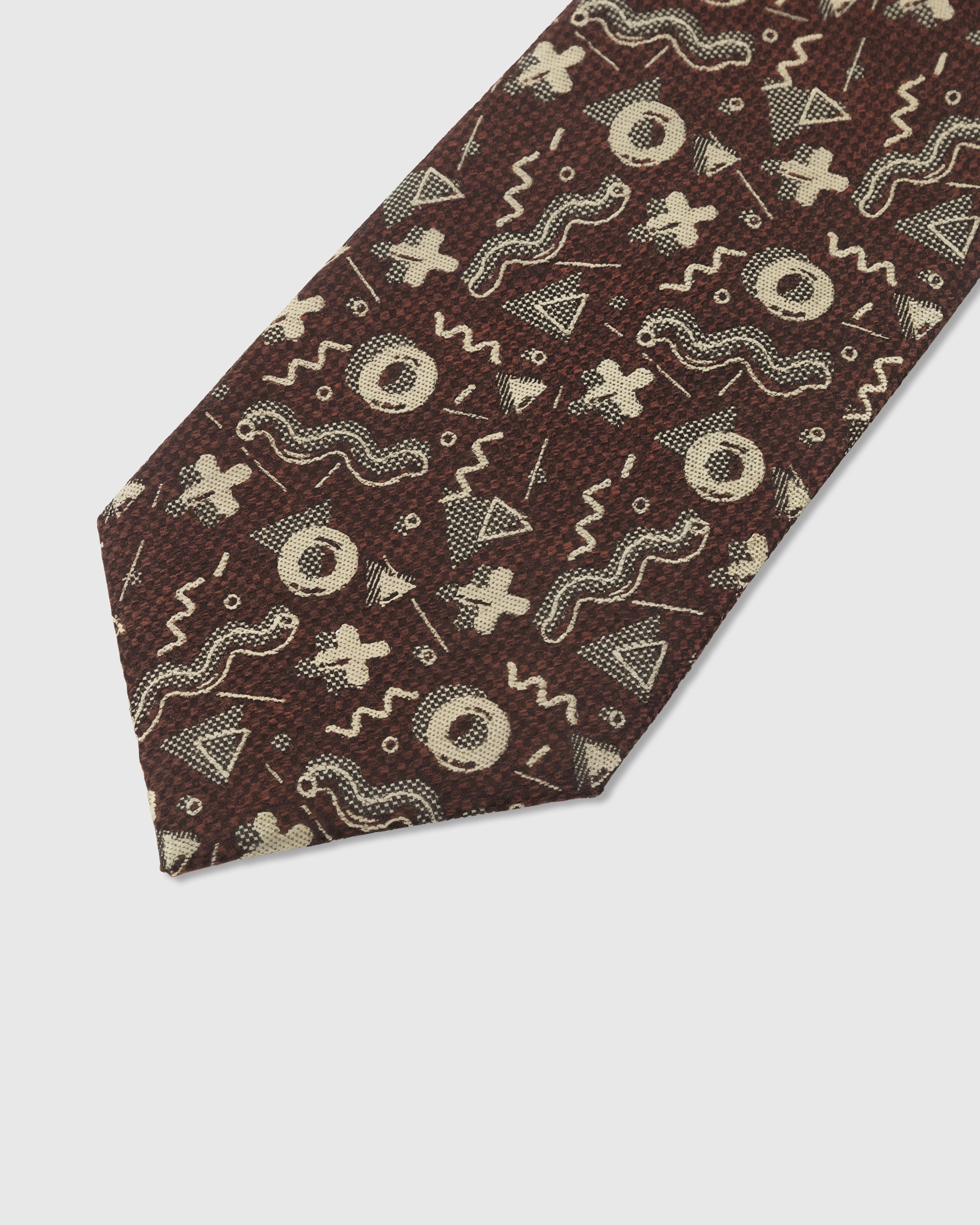 Abstract geometric detail on cocoa mulberry silk tie showing hand-embroidered circles, waves, and crosses by STICKYZOO