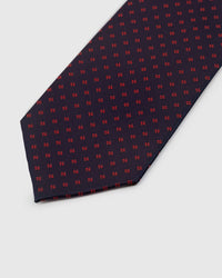 Crimson micro-geometric embroidered detail on midnight navy mulberry silk tie showing raised thread pattern by STICKYZOO