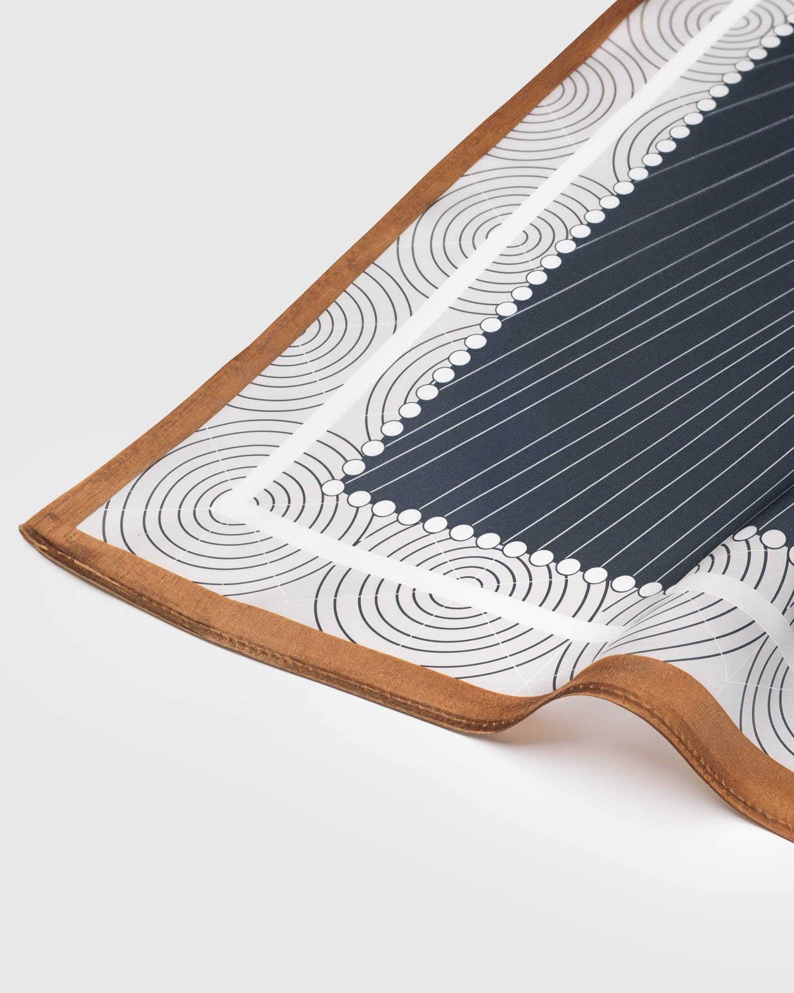 Pure silk scarf showing the cognac border drape and the printed ivory circle field