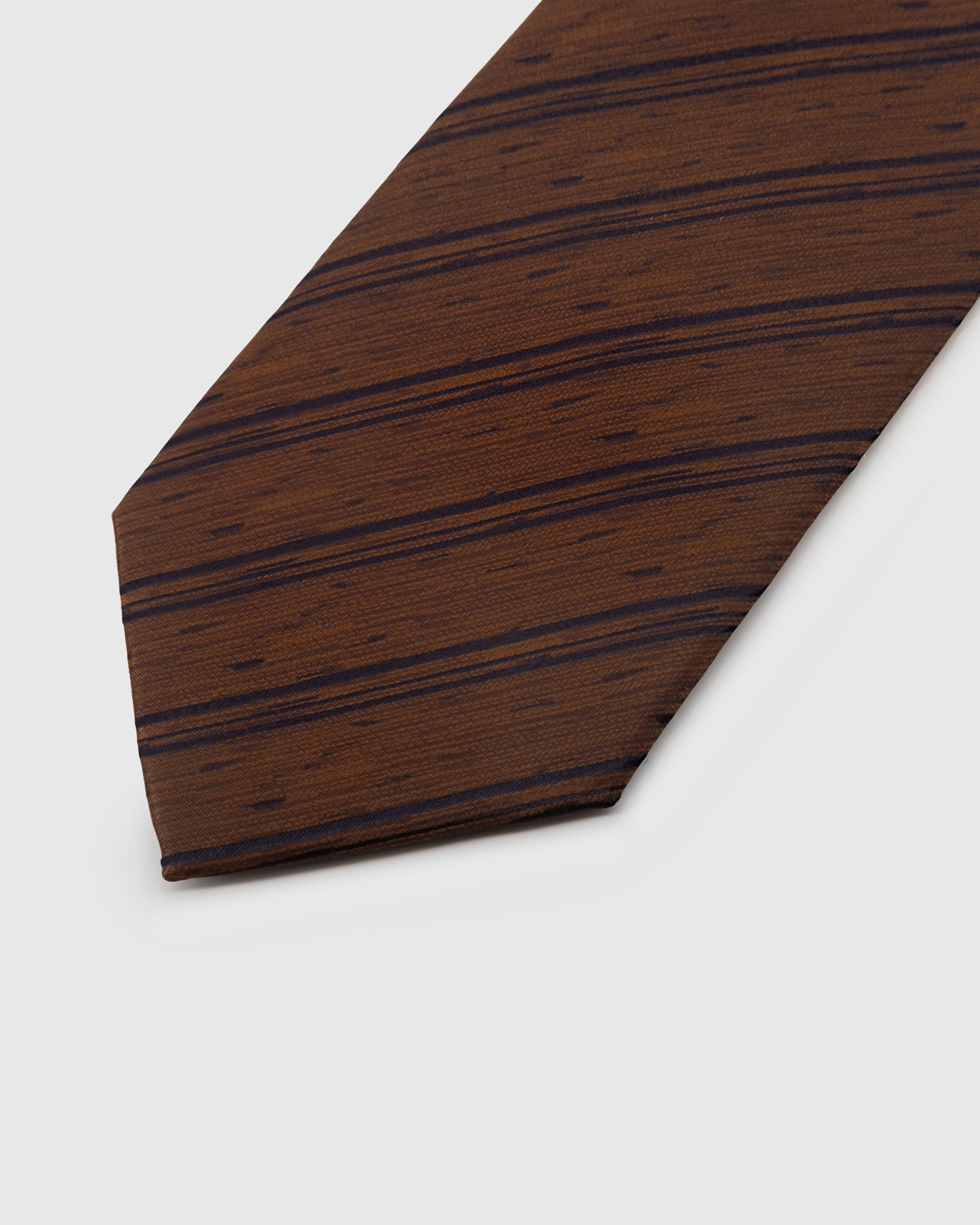 {{Each one stitched by hand}} Navy irregular stripe detail on walnut slub-textured mulberry silk tie showing hand-embroidered thread by STICKYZOO