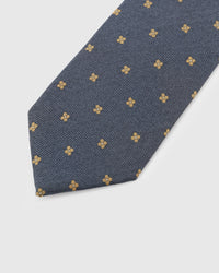 Gold clover motif detail on steel blue herringbone mulberry silk tie showing hand-embroidered thread by STICKYZOO