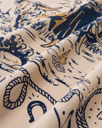 Detail of the hand-illustrated cowgirl scene printed in navy and butter yellow on the cream silk field
```