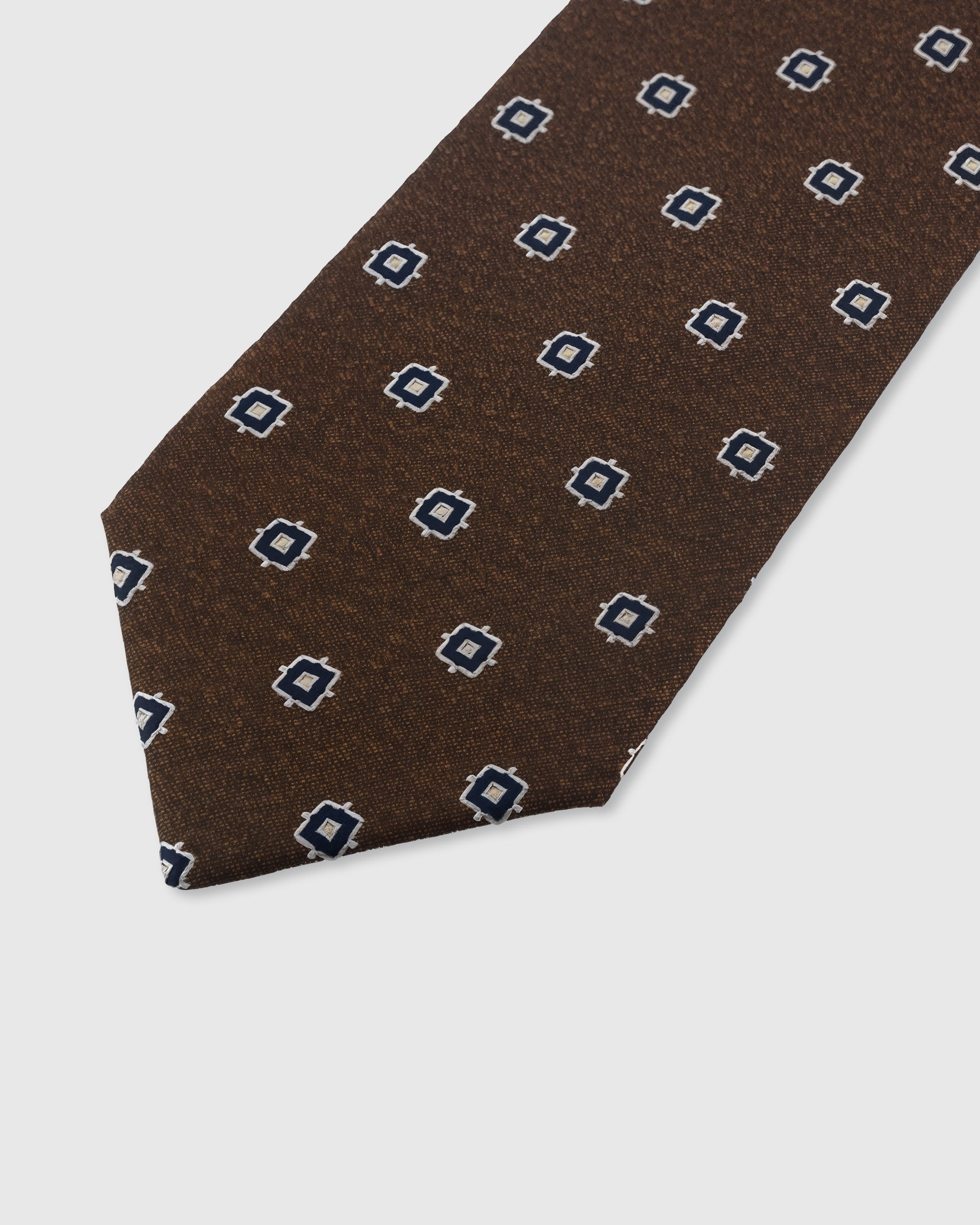 {Embroidered navy square foulard detail} Square foulard detail on umber brown mulberry silk tie showing embroidered pattern by STICKYZOO