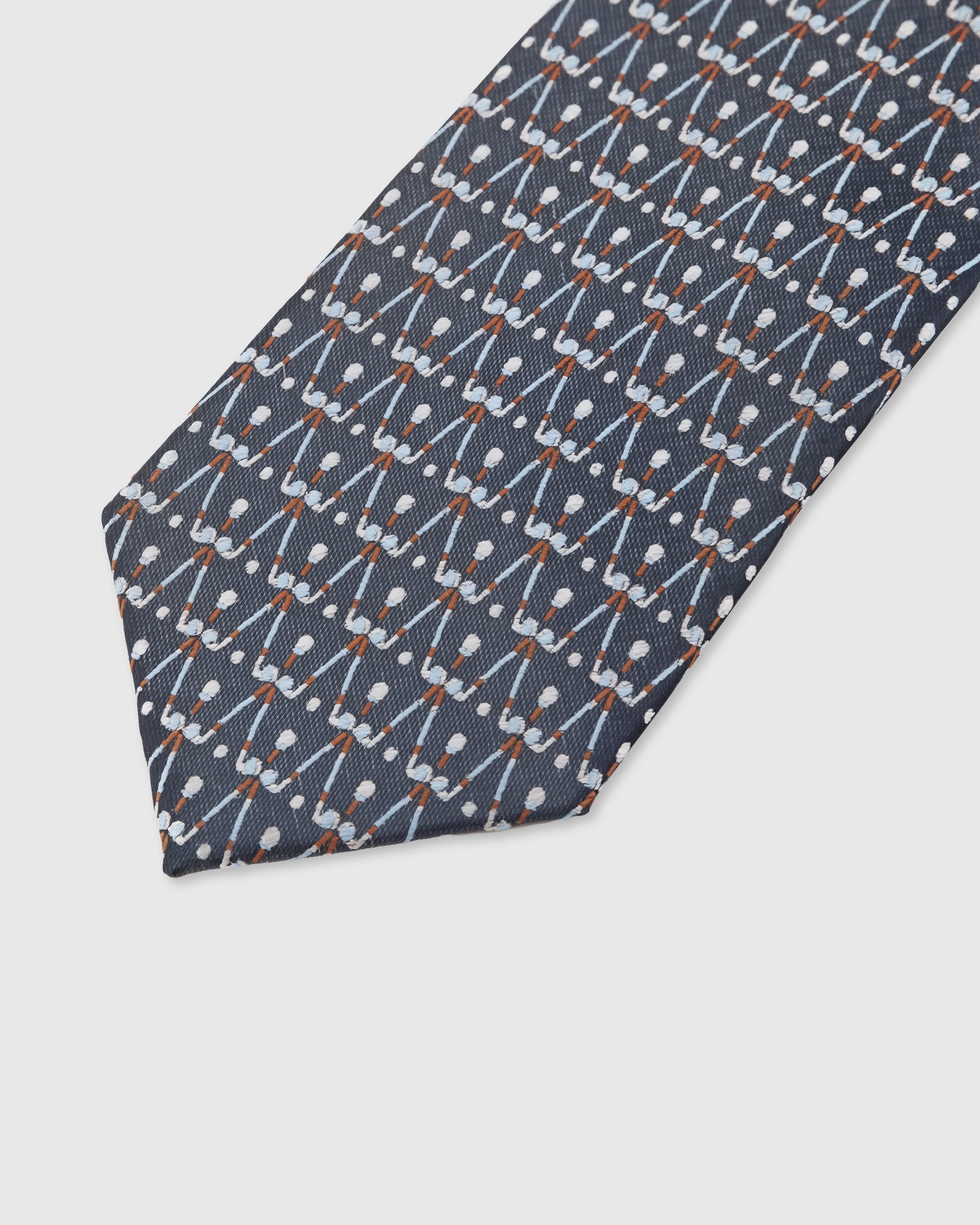 Geometric lattice detail on slate mulberry silk tie showing hand-embroidered copper accents by STICKYZOO