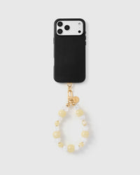 Full phone with butter crystal cluster strap attached on light grey background
