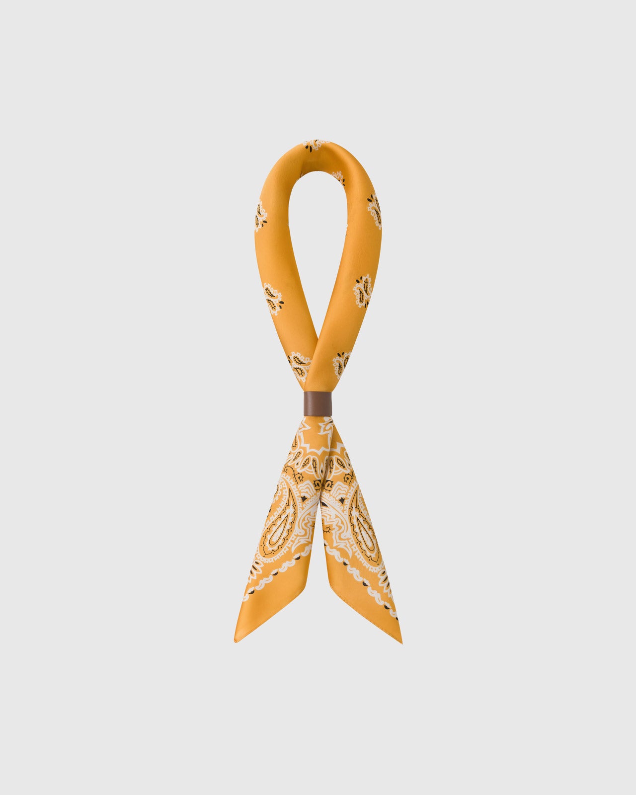 STICKYZOO saffron bandana silk scarf twisted through a leather ring showing the paisley corners and drop-motif field