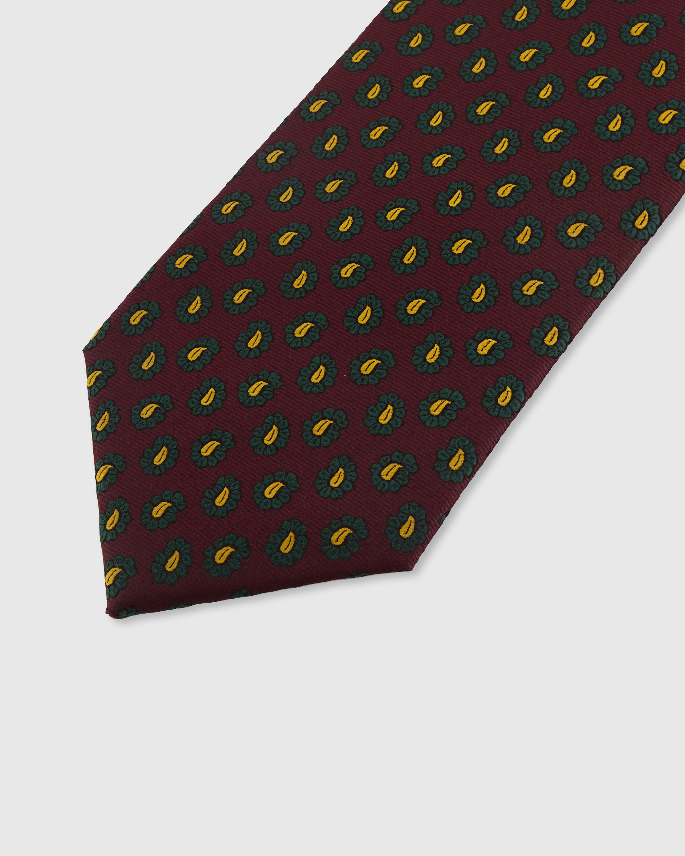 STICKYZOO OXBLOOD PAISLEY TIE — hand-embroidered detail showing emerald and gold miniature paisley drops, stitched not printed
