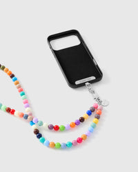 Phone Strap Card seated in a phone case, showing the cross-body strap fits any case. Phone case sold separately.