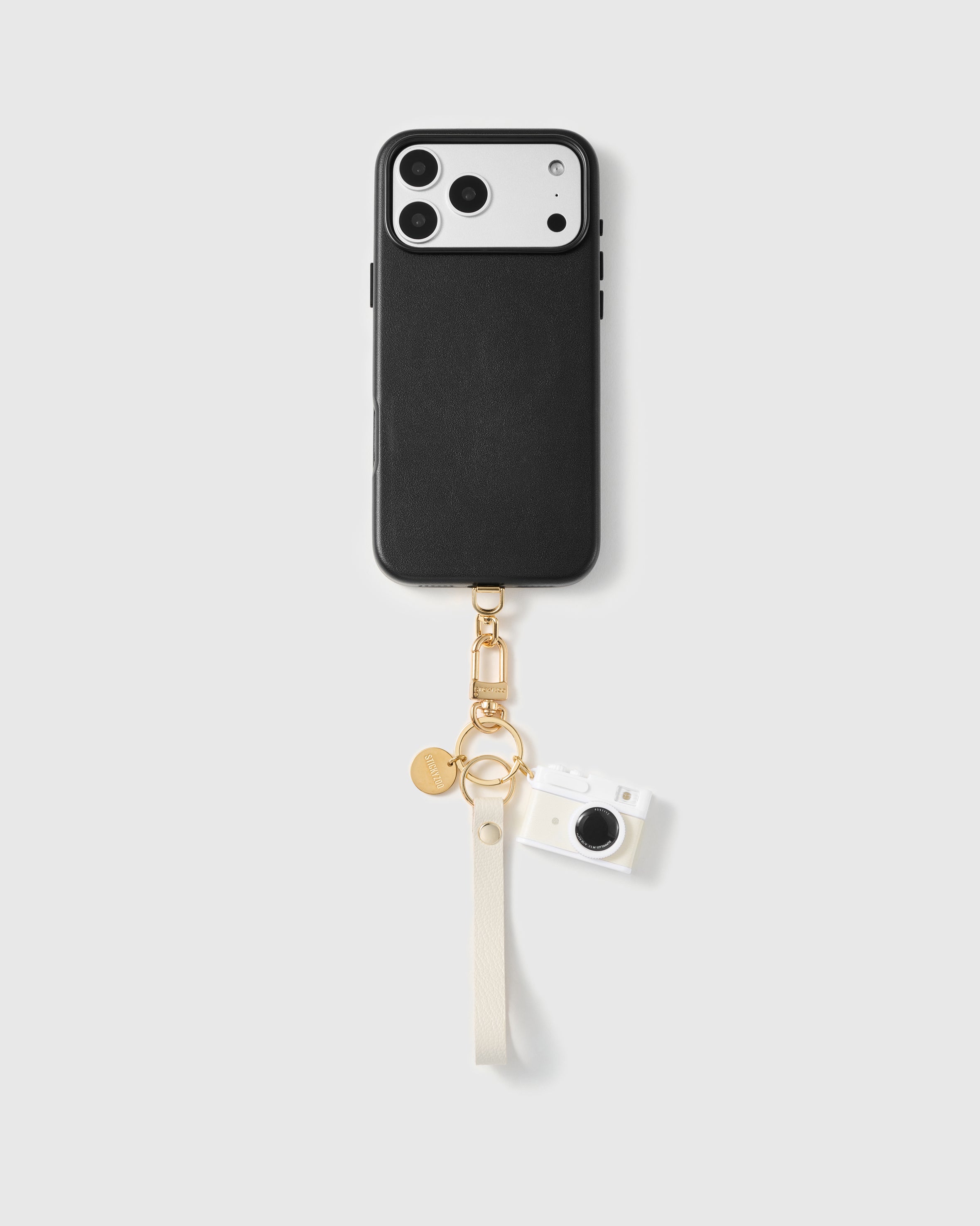 Close-up of pebbled cream French Alran leather phone strap edge with engraved gold STICKYZOO hardware