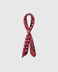 STICKYZOO cardinal bandana silk scarf coiled through a leather loop showing the four-block motif