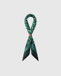 STICKYZOO emerald dotwork silk scarf folded into a bow with the green pattern fanning across the fold