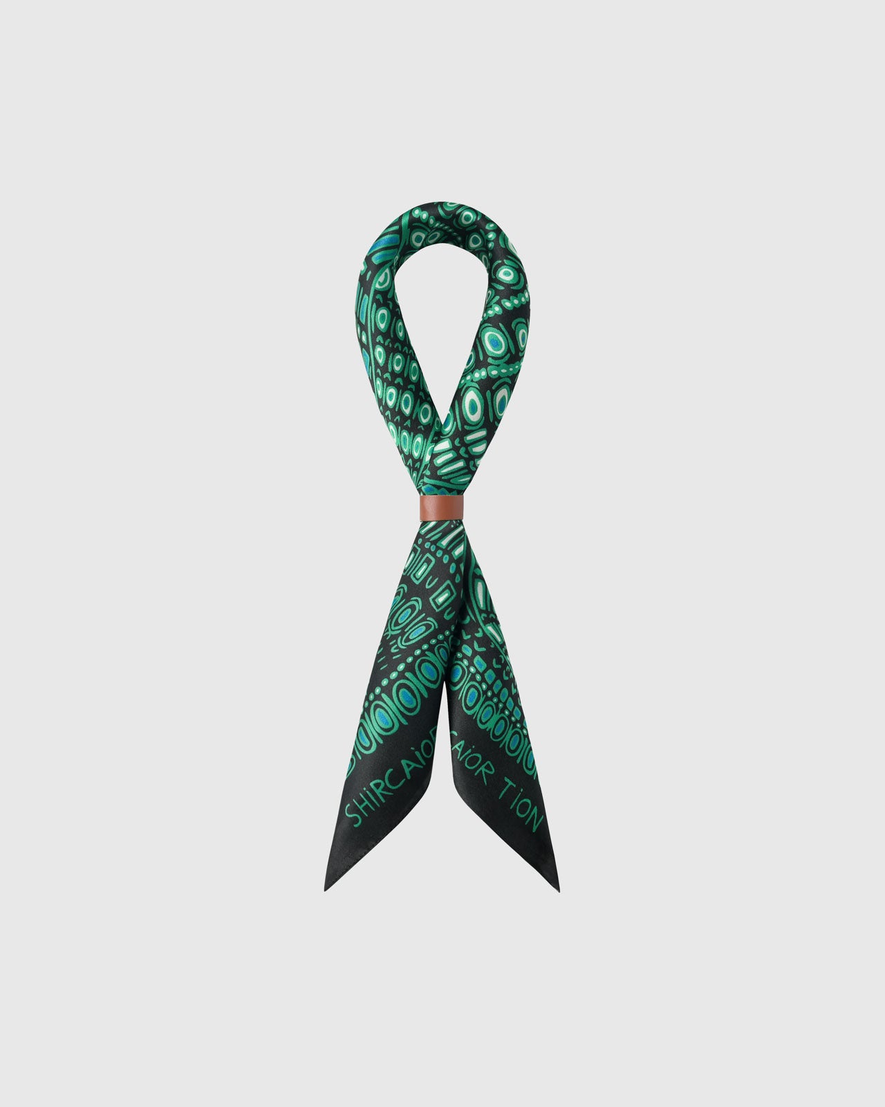 STICKYZOO emerald dotwork silk scarf folded into a bow with the green pattern fanning across the fold
