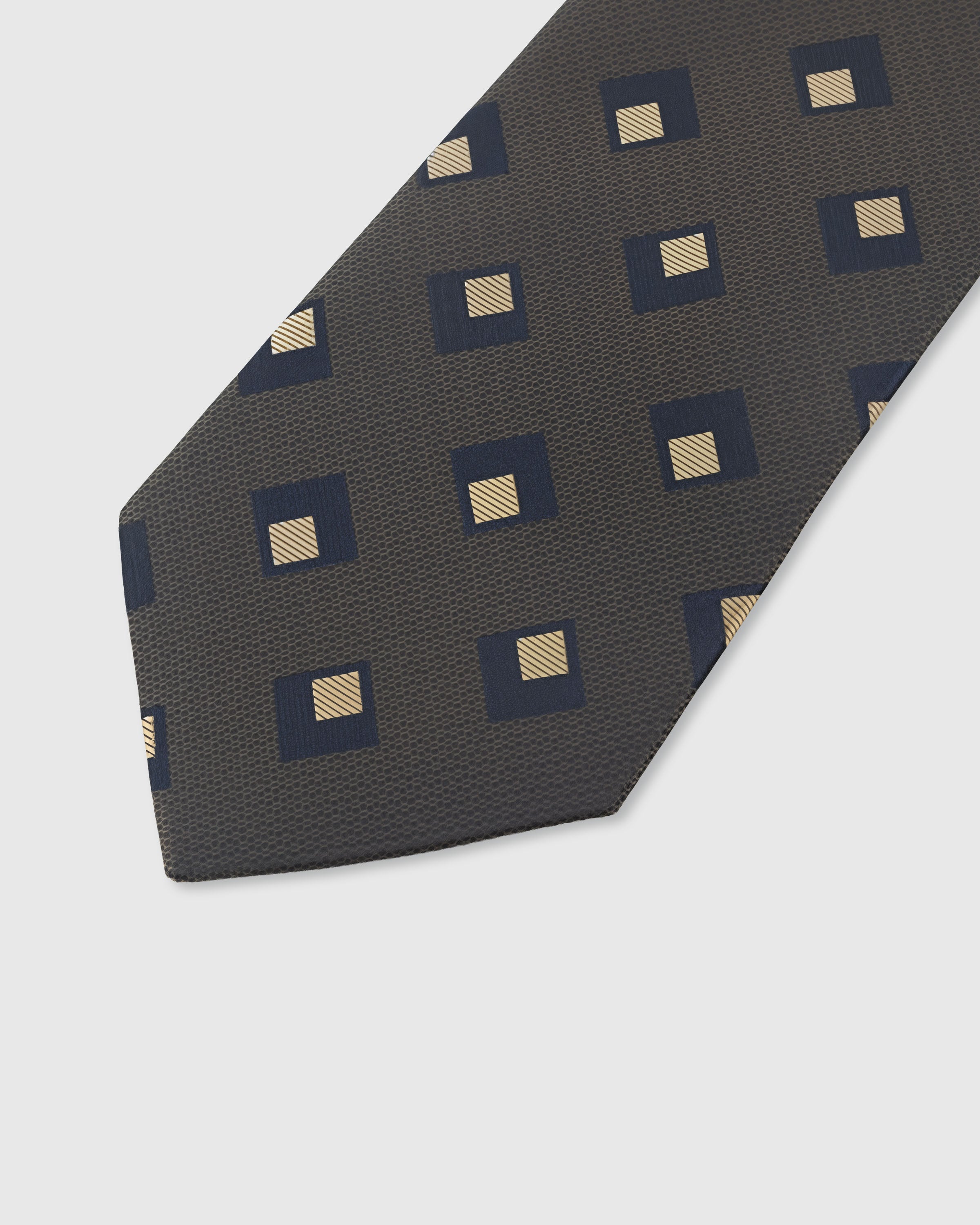 STICKYZOO GRAPHITE DIAMOND TIE — hand-embroidered detail showing navy and gold nested diamond motifs, stitched not printed