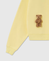 Detail of plush bear and ribbed hem on lemon 450gsm cotton fleece