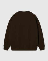 Model wearing Poodle Parade Sweatshirt in dark brown showing dropped shoulders and relaxed fit