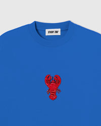 Hand-beaded lobster on the blue Lobster T-Shirt showing red glass beads and layered sequins on 230gsm cool-touch cotton.