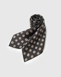 STICKYZOO obsidian coin silk scarf rolled to show the medallion print and the silk hand