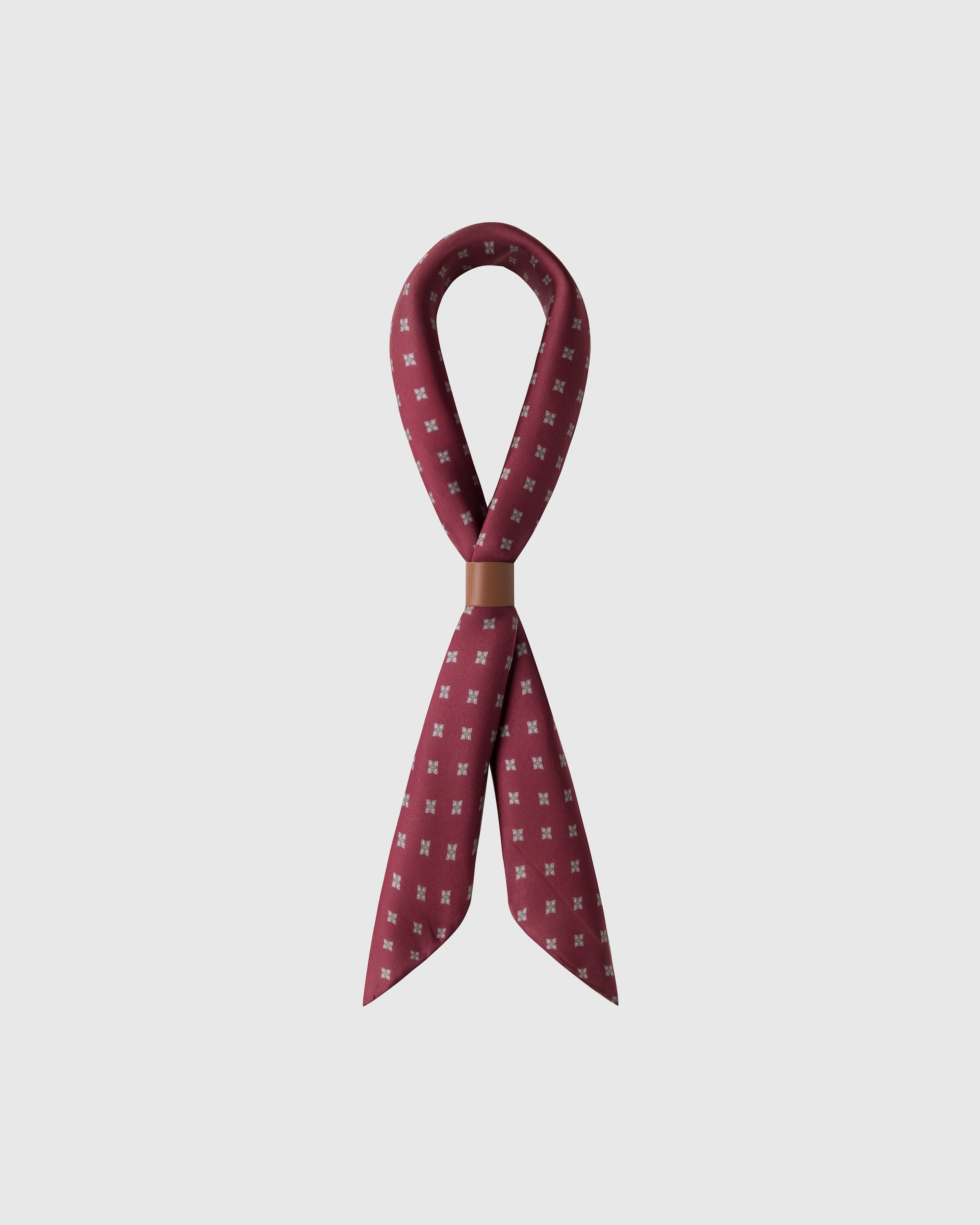 STICKYZOO foulard carré silk scarf looped through a leather cuff showing the neat micro-print