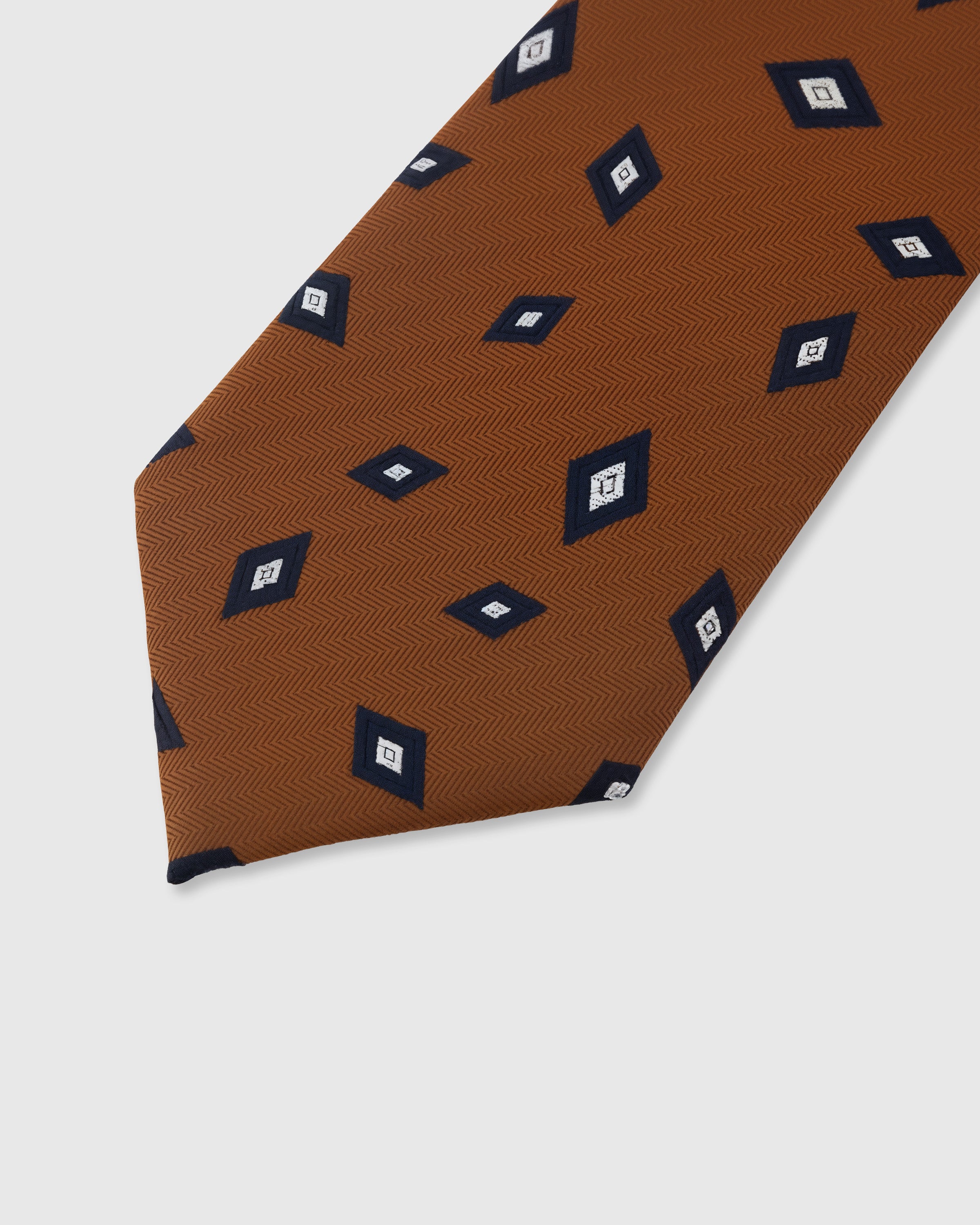 Diamond foulard detail on cognac mulberry silk tie showing hand-embroidered navy motifs by STICKYZOO