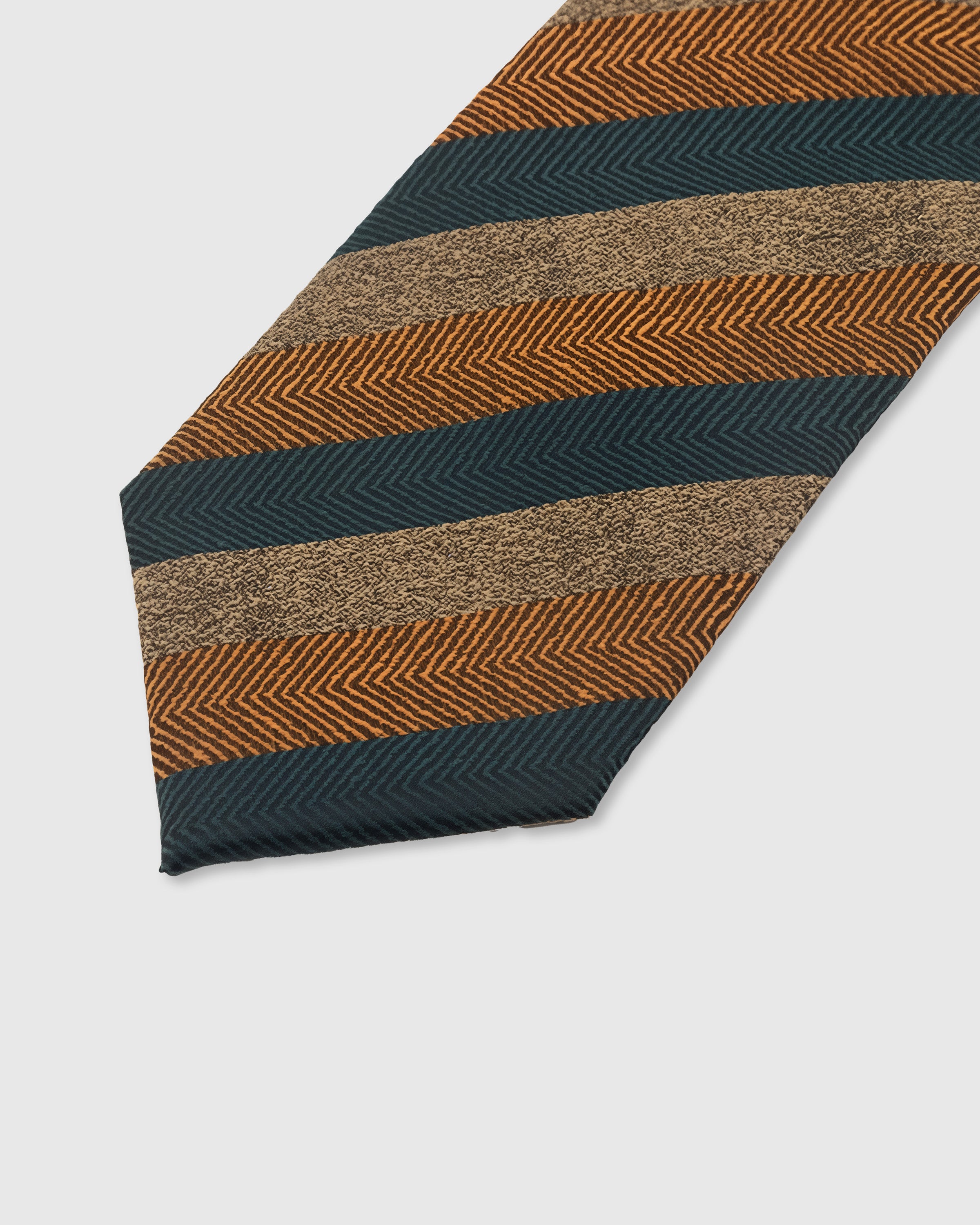 EMBER HERRINGBONE TIE — 45° Italian bias-cut construction with structured interlining, hand-finished slip stitching visible on interior