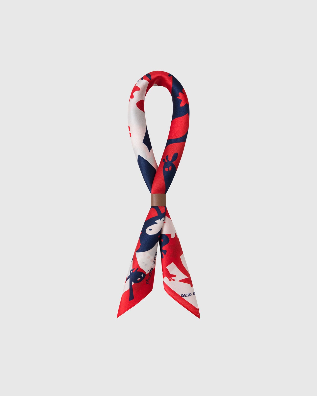 STICKYZOO giraffe parade silk scarf folded into a bow showing the red field and navy figures
