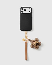 Leopard star leather phone strap clipped to a black phone case, hands-free wrist strap