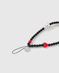 Close-up of the silver-tone engraved STICKYZOO disc, black stretch-cord loop, dalmatian puppy charm and red glossy heart on the beaded strap.