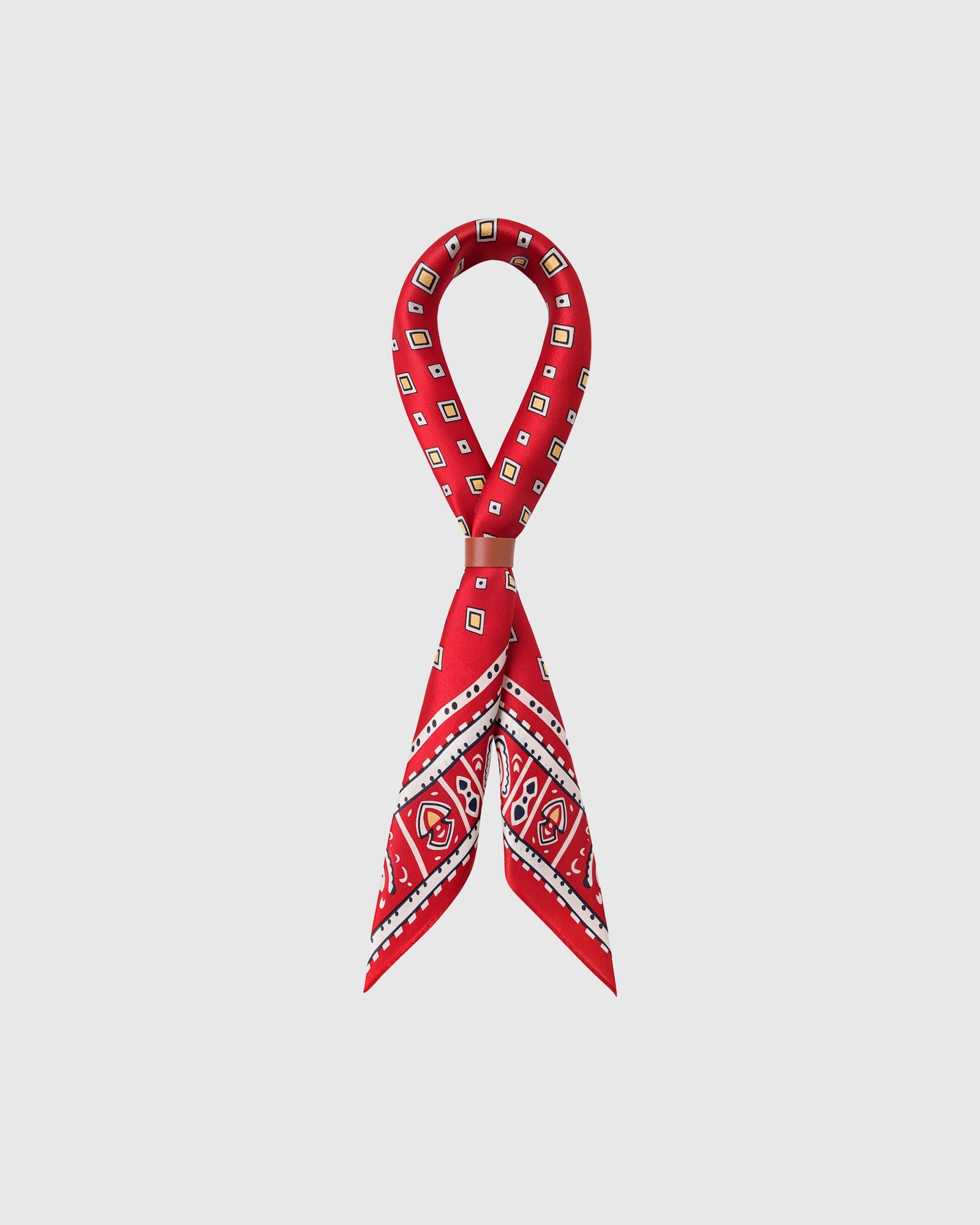 STICKYZOO poppy foulard silk scarf looped through a leather slide showing the tile border on red
