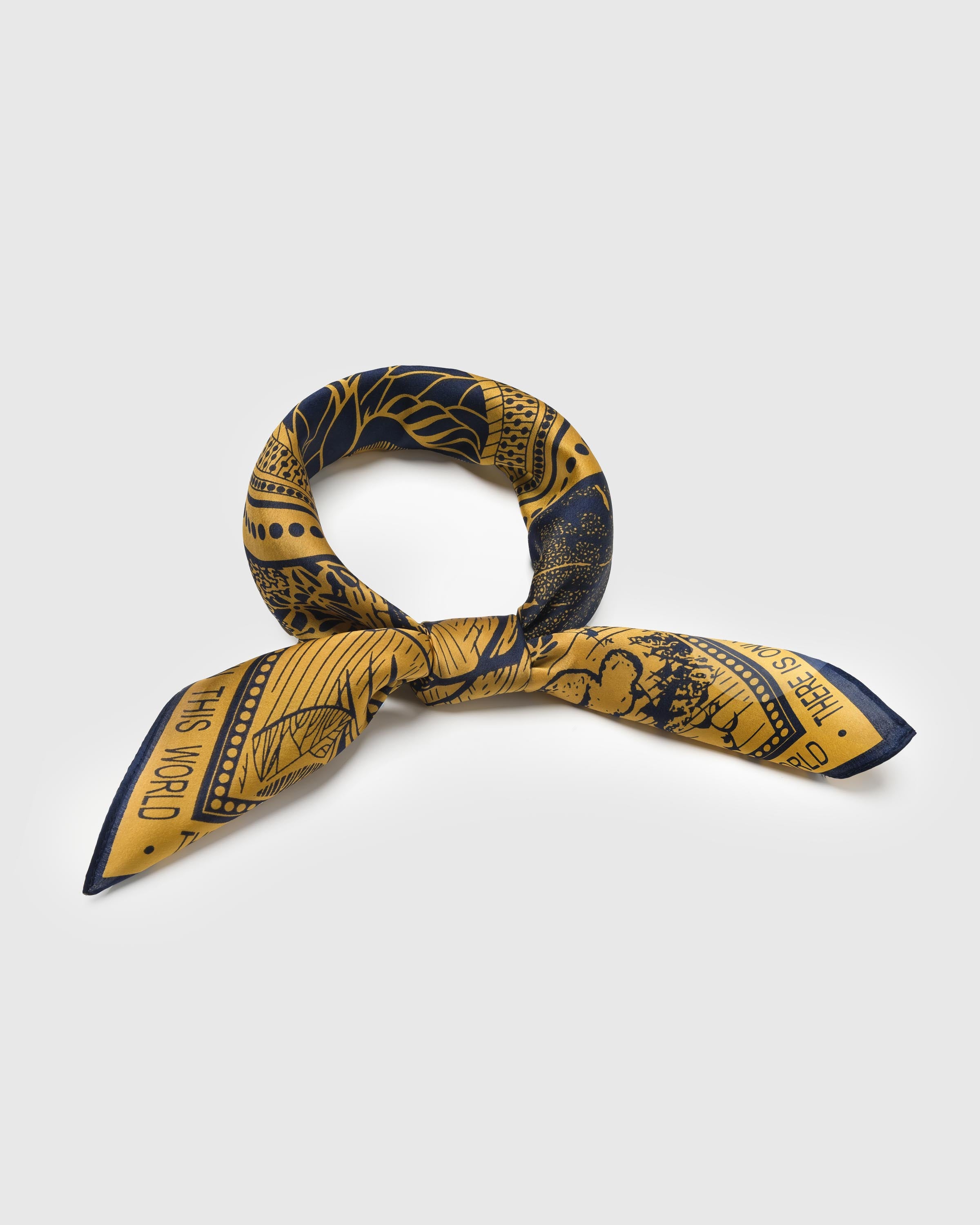 STICKYZOO golden paradise silk scarf knotted at the front showing the woodcut paradise scene