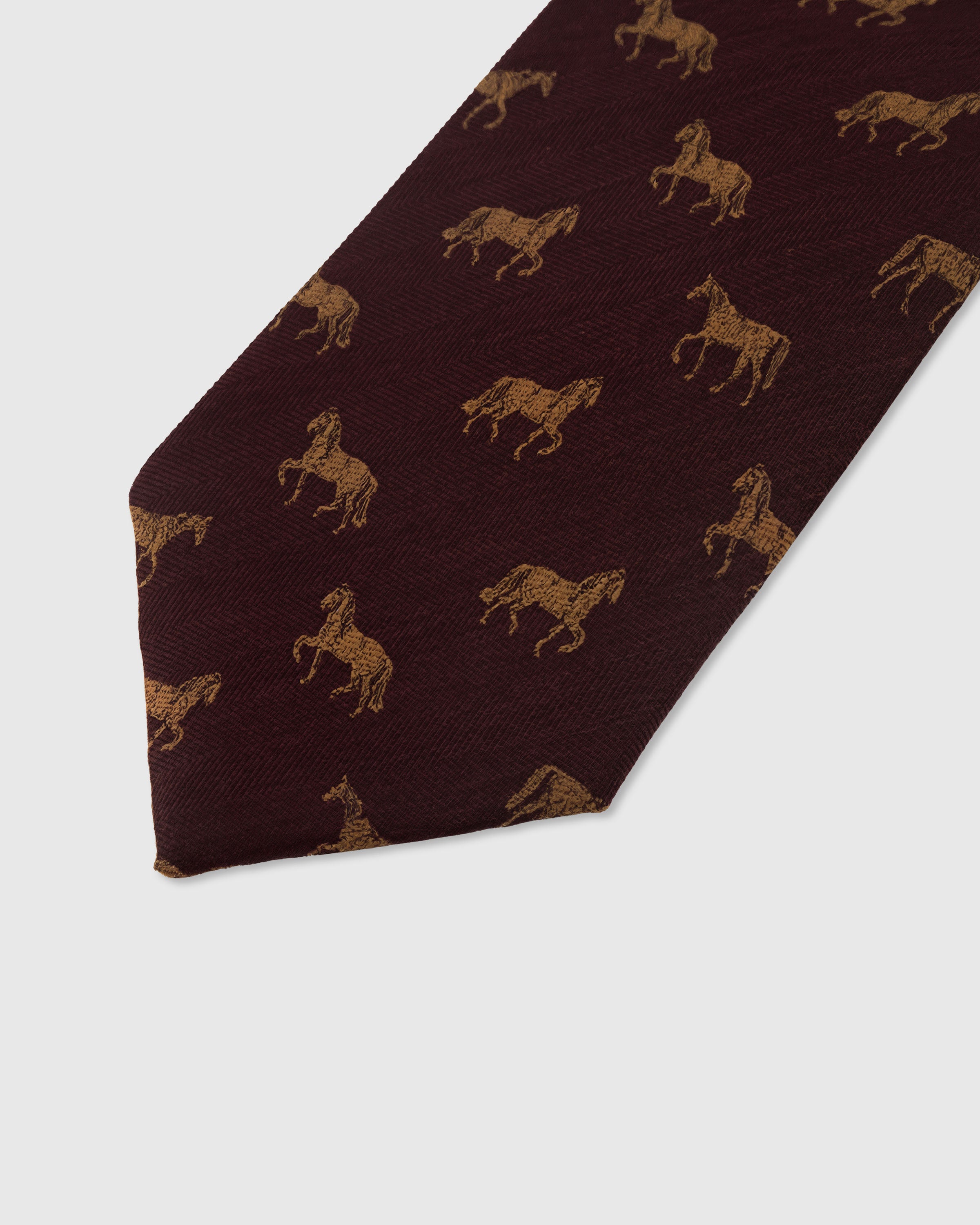Amber stallion motif detail on garnet mulberry silk tie showing raised hand-embroidered thread by STICKYZOO