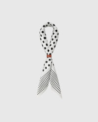 STICKYZOO ivory dot silk scarf draped in a ribbon fold with a leather slide showing the black polka print