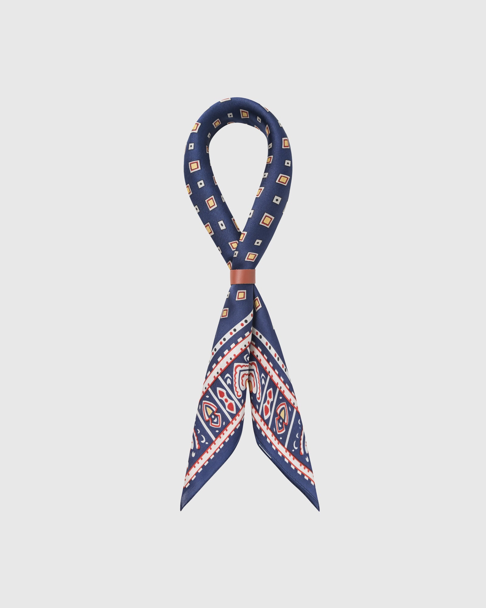 STICKYZOO navy foulard silk scarf looped through a leather slide showing the tile border