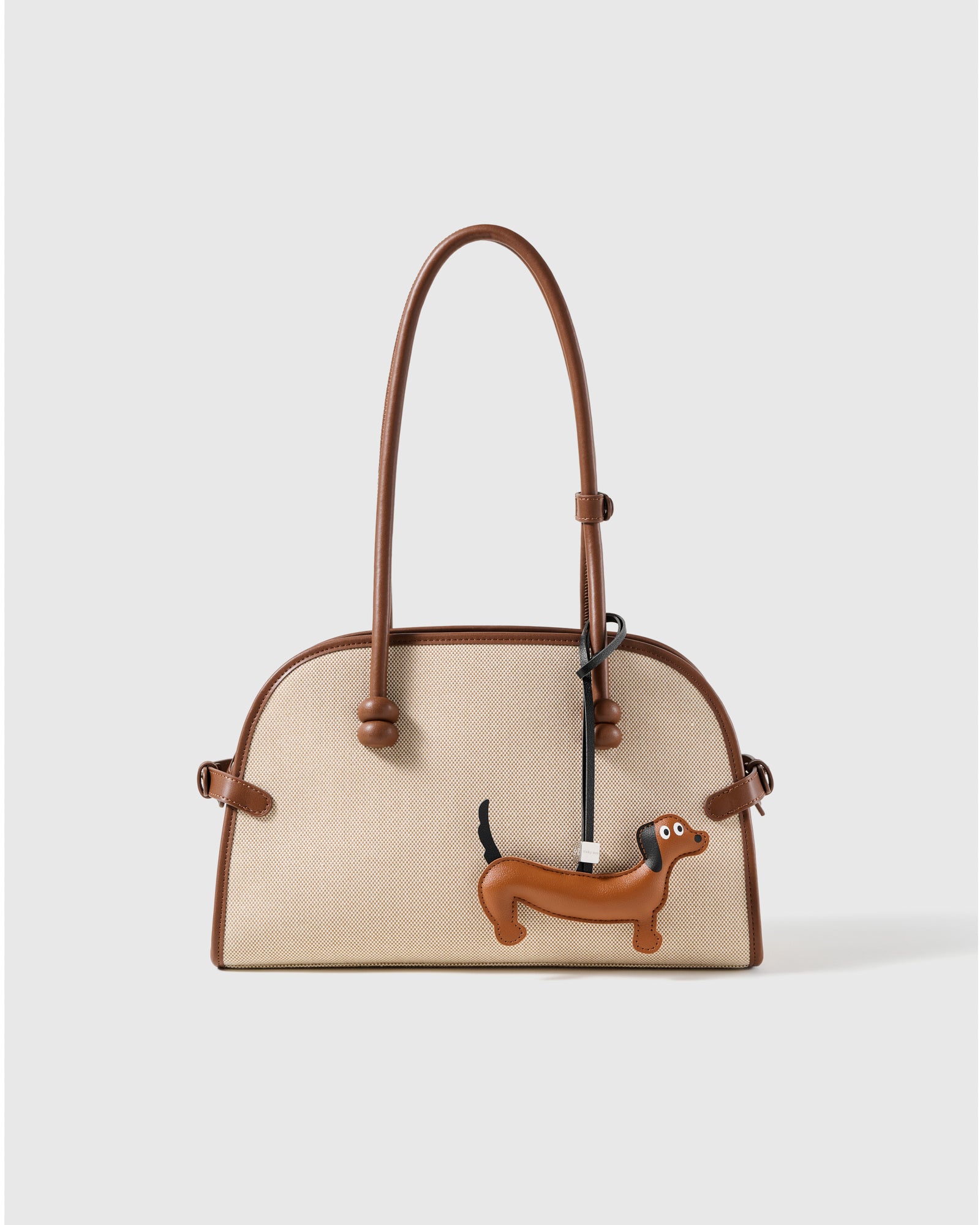 STICKYZOO leather dachshund charm clipped to a handbag, an everyday detail people notice