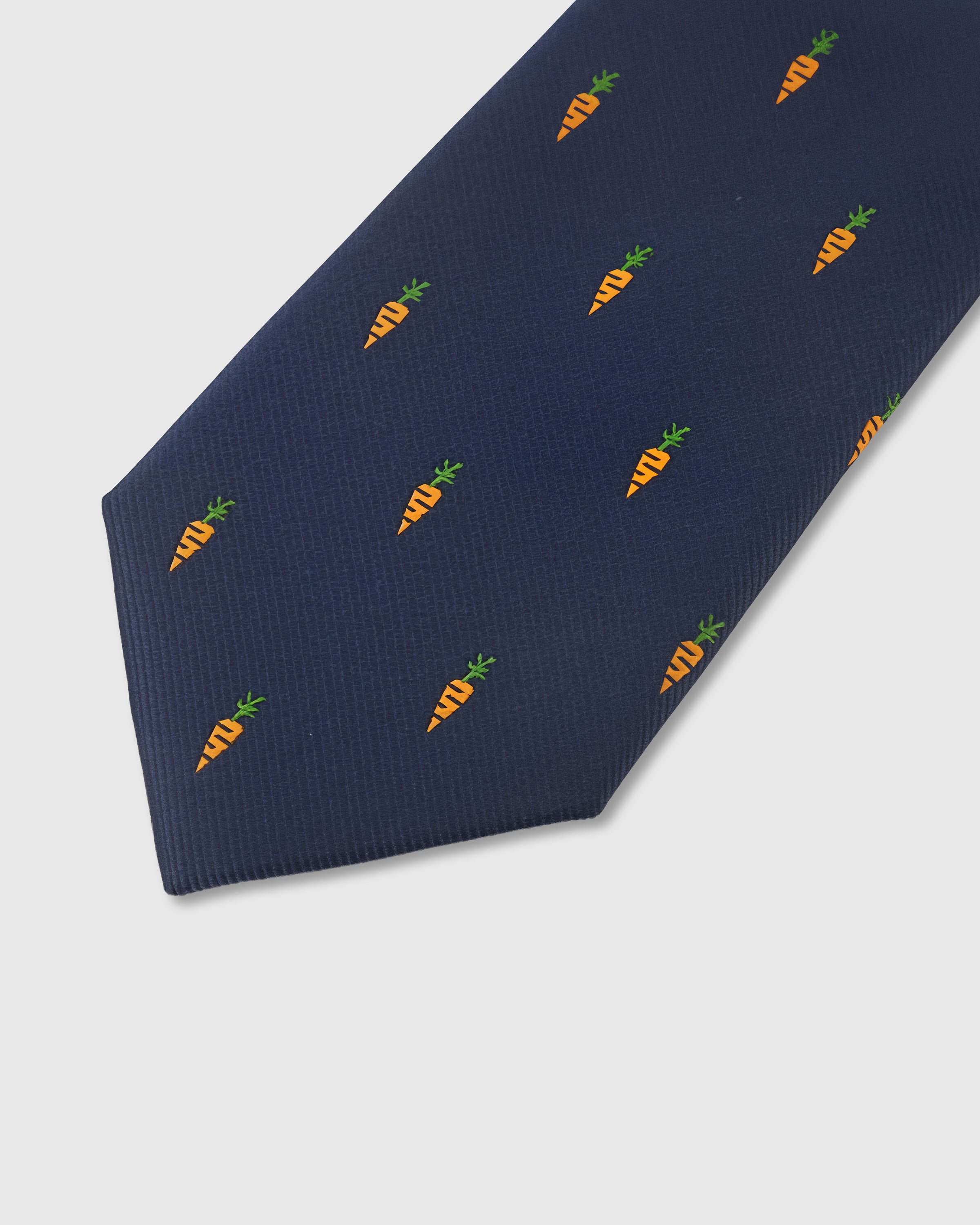 Amber carrot motif detail on navy mulberry silk tie showing raised hand-embroidered thread by STICKYZOO