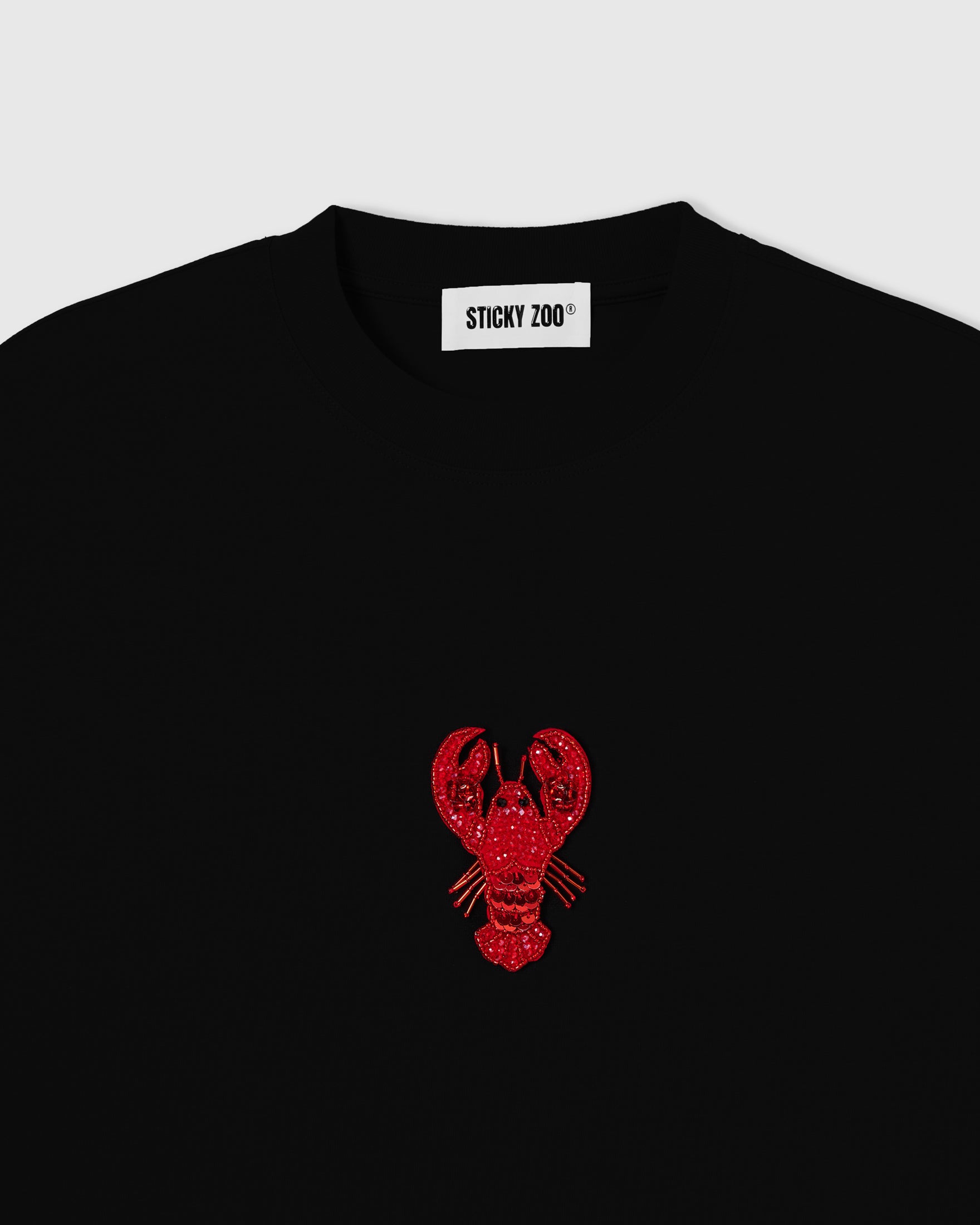 Hand-beaded lobster on the Lobster T-Shirt showing red glass beads and layered sequins on 230gsm cool-touch cotton.