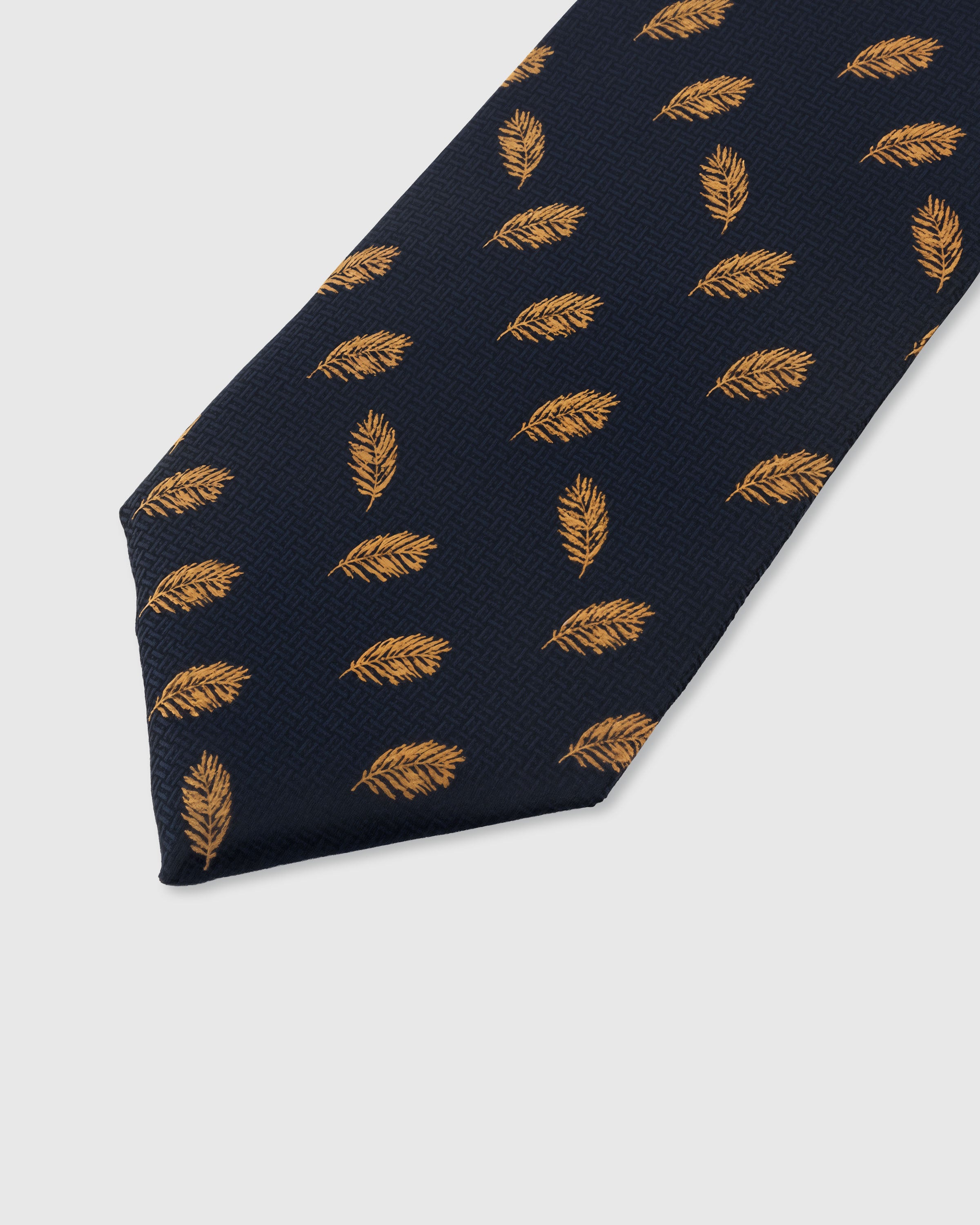 STICKYZOO NAVY FEATHER TIE — hand-embroidered detail showing golden amber floating feather motifs, stitched not printed