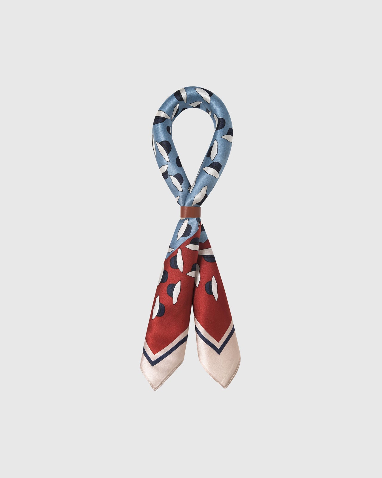STICKYZOO azure petal silk scarf folded into a bow showing the rust border and striped frame meeting the print