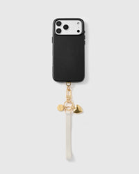 Golden heart leather phone strap looped on a black phone case, worn hands-free