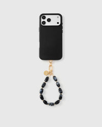 Obsidian marble phone strap hanging from black phone case showing wrist carry functionality