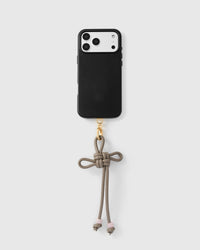 Knotted bow phone strap attached to black phone case showing universal compatibility