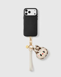 Snow-leopard leather phone strap looped on a black phone case, worn hands-free